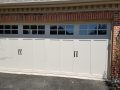 A white garage door with windows on the top pane.