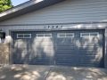 A charcoal-colored garage door with white grills in Plainfield IL.