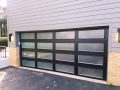 A black garage door with frosted glass windows